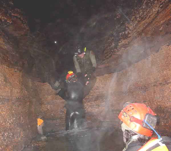 TJ Helps Deb up a water fall at Snail Shell Cave - Tennessee September 2004